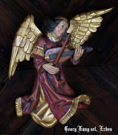 Engel mit goldenem Flügel, der ein Musikinstrument spielt, in roter und goldener Kleidung.