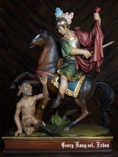 Reiterstatue eines Heiligen, der einen hilfesuchenden Mann auf dem Boden berührt.