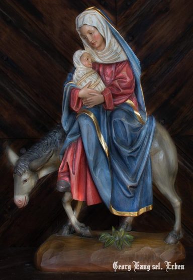 Maria mit dem Jesuskind, sitzend auf einem Esel, detailreiche Statue.