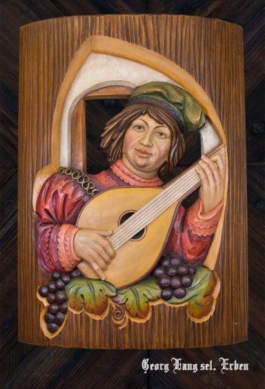 Mann mit Laute, umgeben von Trauben, in einem kunstvollen Relief.