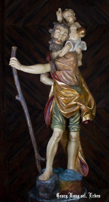 Heilige Figur eines Hirten mit einem Kind auf den Schultern und einem Stock in der Hand.