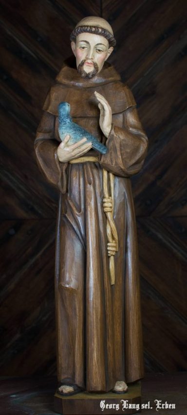 Eine Holzstatue von einem Mönch mit einem Vogel in der Hand.