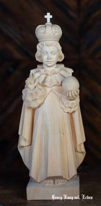 Eine Statue eines königlichen Kindes mit Krone und Reichsapfel, in traditioneller Kleidung.